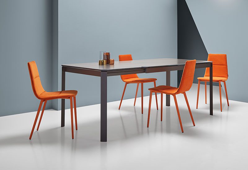 Design eetkamerstoelen van Mobliberica bij Houweling Interieurs. Het zijn moderne eetkamerstoelen uitgevoerd met oranje stof en poten.