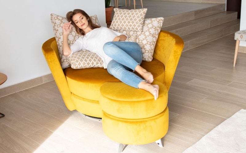 Loveseat van Fama bij Houweling Interieur. ronde loveseat in gele stof met hocker.