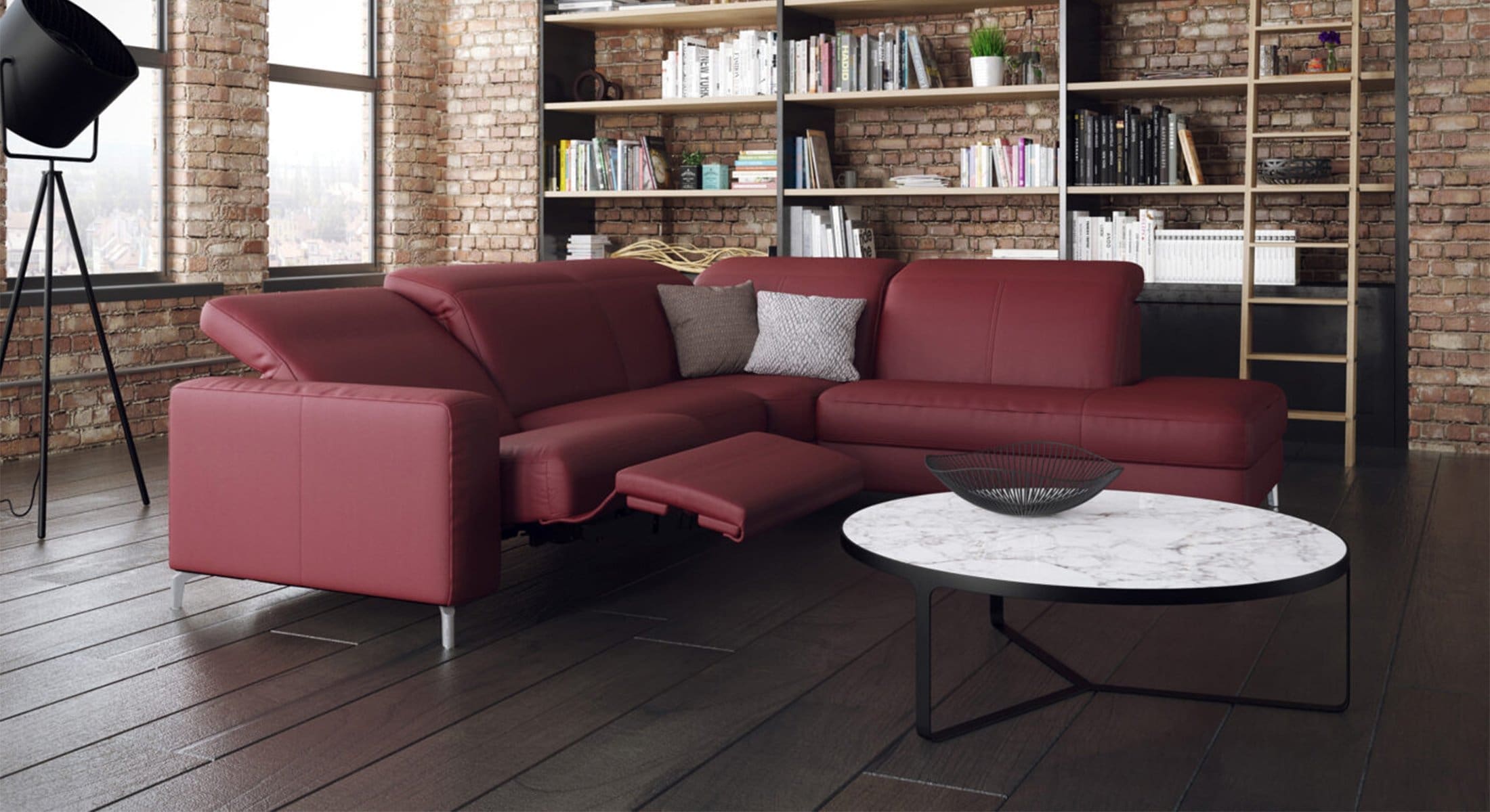 Relaxbank bij Houweling Interieur. Het is een bank met relaxfunctie uitgevoerd in rood leer.