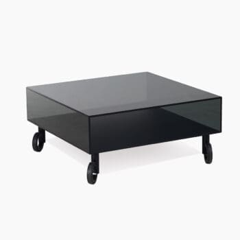 Glazen salontafel bij Houweling Interieur. Het is een vierkante salontafel van zwart glas op wieltjes.