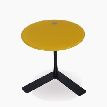 Glazen bijzettafel bij Houweling Interieur. Het is een ronde bijzettafel met geel blad en platte L-vormige poot.