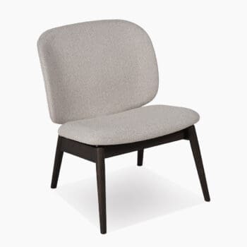 Lounge fauteuil bij Houweling Interieur. Het is een Scandinavisch fauteuil uitgevoerd in crème stof en donkerhout armen en poten.