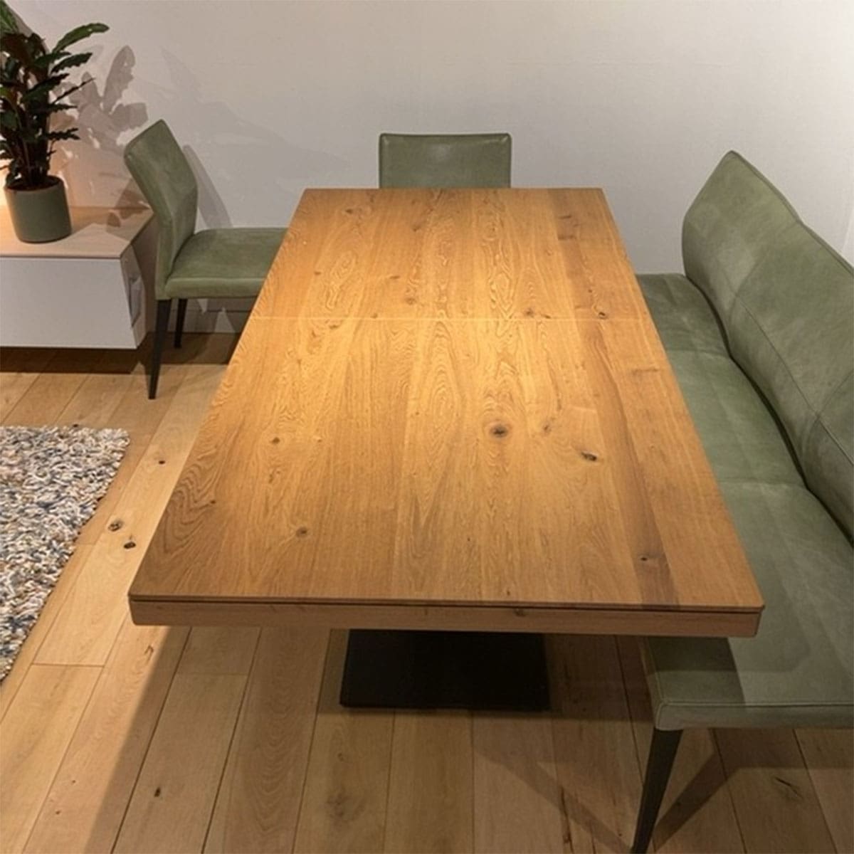 Showroom model van een uitschuiftafel bij Houweling Interieur. Het is een uitschuifbare eettafel met centrale zwarte poot.