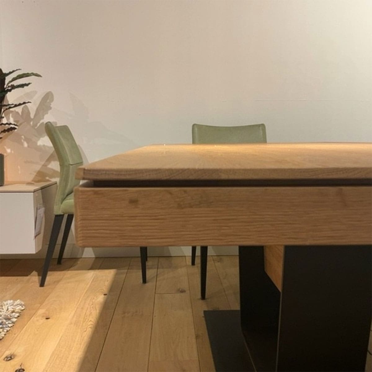 Showroom model van een uitschuiftafel bij Houweling Interieur. Het is een uitschuifbare eettafel met centrale zwarte poot.