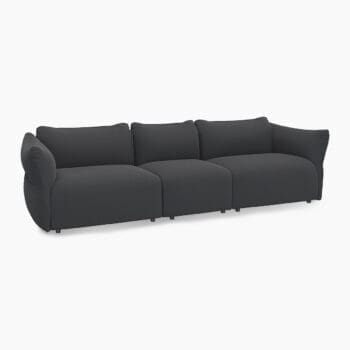 Lounge bank van Flexlux bij Houweling Interieur. Het is een design bank met ronde vormen en een lage zit uitgevoerd in grijze stof.