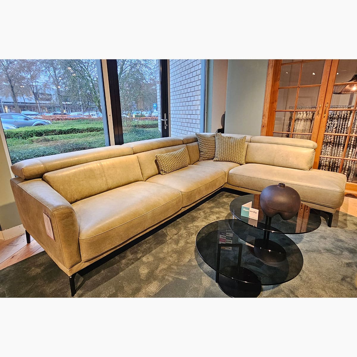 Showroom model van een leren hoekbank bij Houweling Interieur. Moderne hoekbank uitgevoerd in leer Olive.