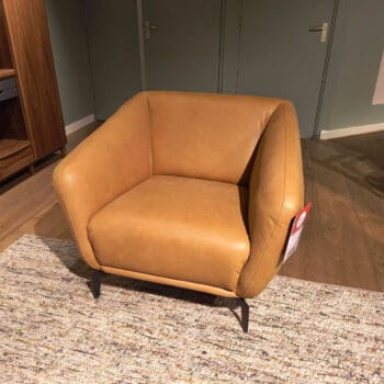 Showroom model van een leren fauteuil bij Houweling Interieur. Moderne fauteuil uitgevoerd in cognac leer.