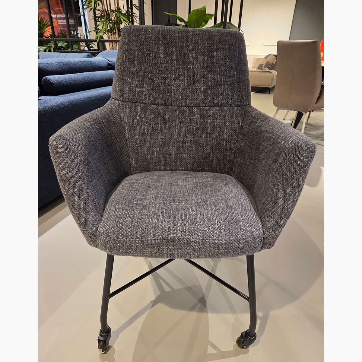 Showroom model van moderne eetkamerstoel bij Houweling Interieur. Armstoel uitgevoerd in blauwe stof.