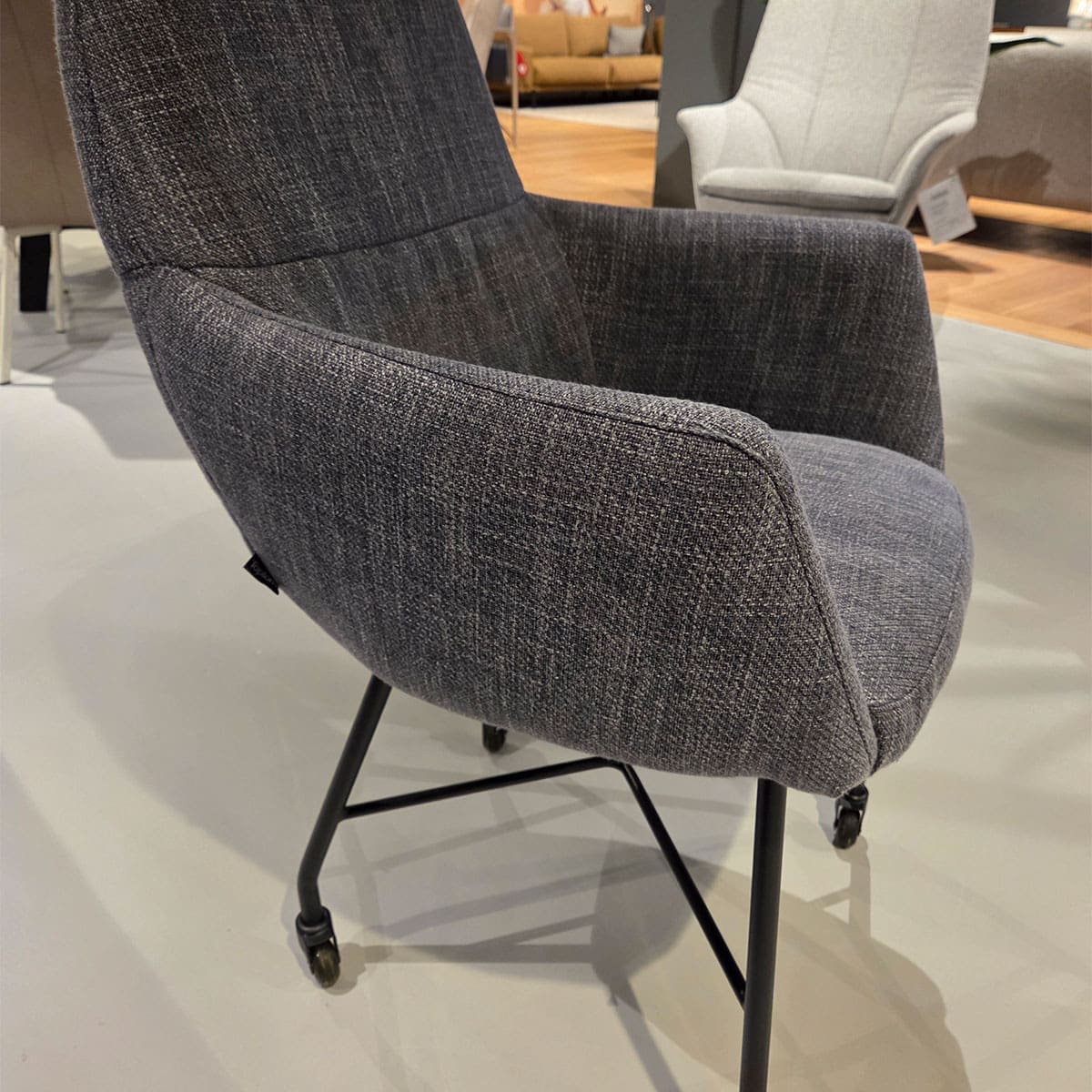 Showroom model van moderne eetkamerstoel bij Houweling Interieur. Armstoel uitgevoerd in blauwe stof.