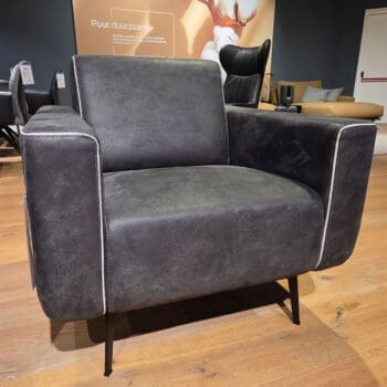 Showroom model van leren fauteuil bij Houweling Interieur. Moderne fauteuil van Topform in antraciet leer en lichte biezen.