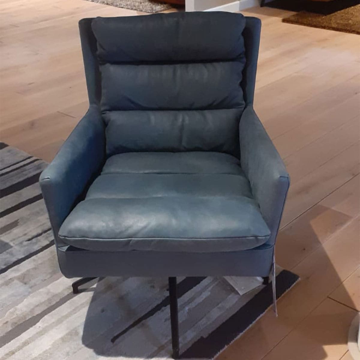 Showroom model van een moderne fauteuil bij Houweling Interieur. Luxe fauteuil uitgevoerd in blauw leder.