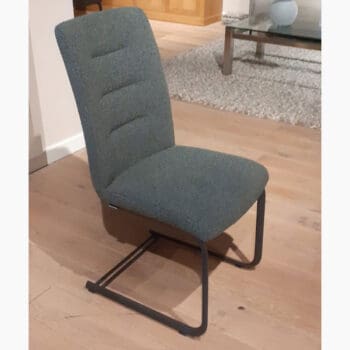 Showroom model van een luxe eetkamerstoel bij Houweling Interieur. Eetkamerstoel uitgevoerd in grijsblauwe stof.