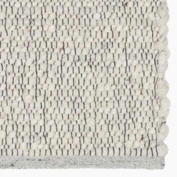 Wollen vloerkleed van De Munk Carpets bij Houweling Interieur. Karpet uitgevoerd in crème tinten en zwarte accenten.