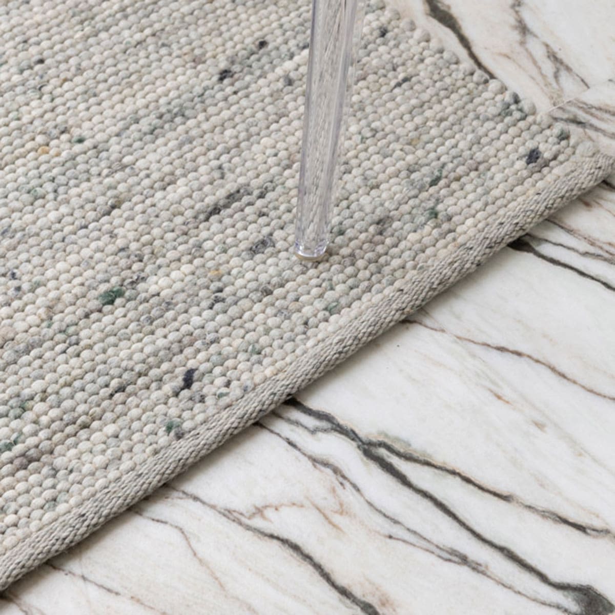 Wollen vloerkleed bij Houweling Interieur van De Munk Carpets. Karpet uitgevoerd in crème, met zwart en blauw accenten.