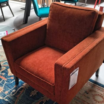 Showroommodel van een moderne bij Houweling Interieur. Design fauteuil uitgevoerd in oranjebruine stof.
