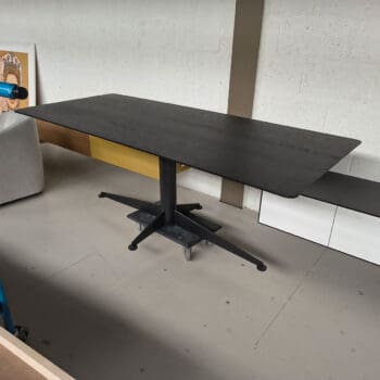 Showroommodel van een houten eettafel bij Houweling Interieur. Design eettafel uitgevoerd in donkerbruin eikenhout.