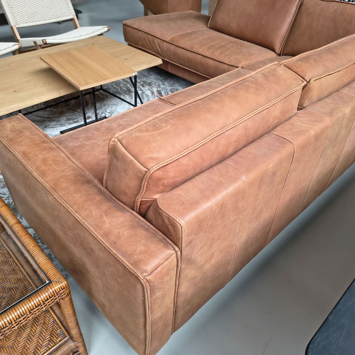 Showroommodel van een leren hoekbank bij Houweling Interieur. Moderne hoekbank uitgevoerd in cognackleurig leer.