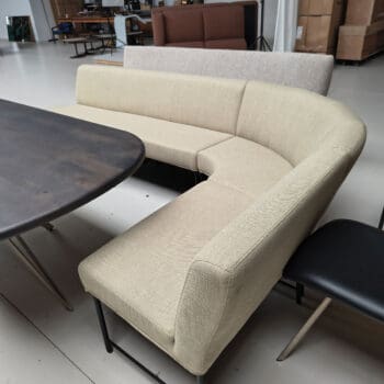 Showroommodel van een ronde eetbank bij Houweling Interieur. Eetkamerbank met hoek uitgevoerd in lichtgroene stof.