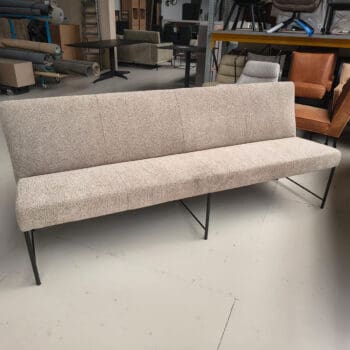Showroommodel van een eetkamerbank bij Houweling Interieur. Moderne eetbank uitgevoerd in beige stof en metalen onderstel.
