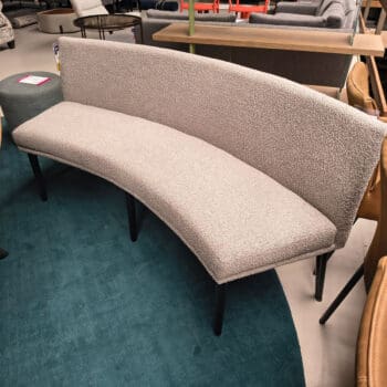 Showroommodel van een ronde eetbank bij Houweling Interieur. Eetkamerbank uitgevoerd met crème stof en zwarte poten.