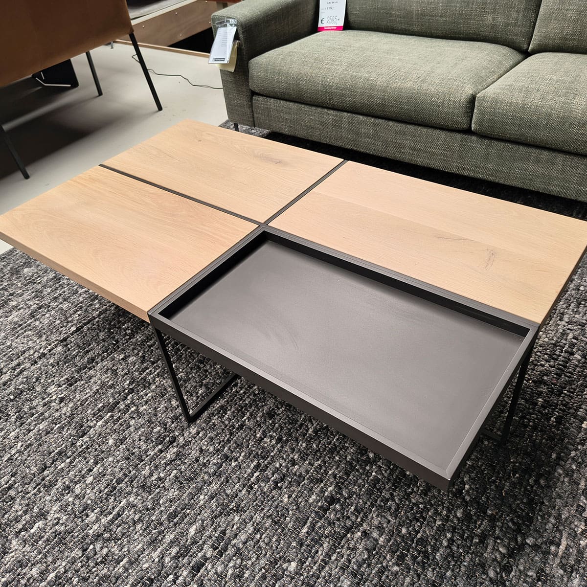 Showroommodel van een houten salontafel bij Houweling Interieur. Design salontafel uitgevoerd in antraciet stof.