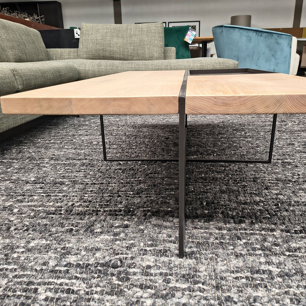 Showroommodel van een houten salontafel bij Houweling Interieur. Design salontafel uitgevoerd in antraciet stof.