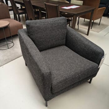 Showroommodel van een moderne fauteuil bij Houweling Interieur. Design fauteuil uitgevoerd in antraciet stof.