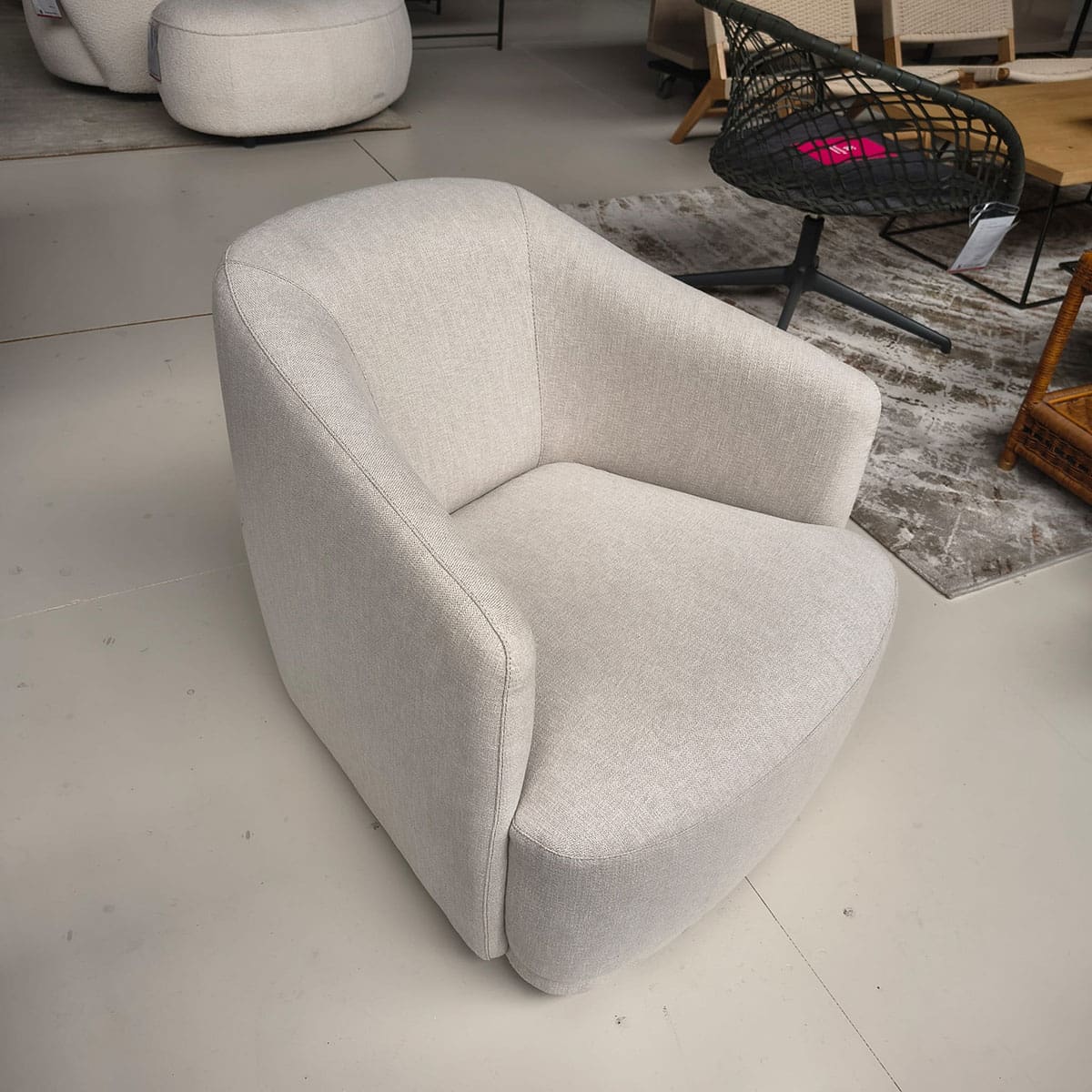 Showroommodel van een moderne fauteuil van Olta bij Houweling Interieur. Design fauteuil uitgevoerd in crème stof.