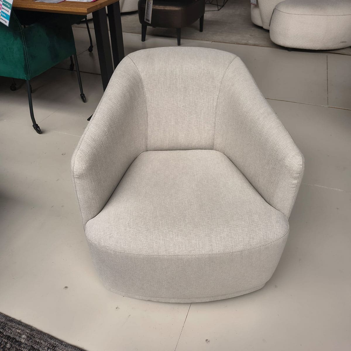 Showroommodel van een moderne fauteuil van Olta bij Houweling Interieur. Design fauteuil uitgevoerd in crème stof.