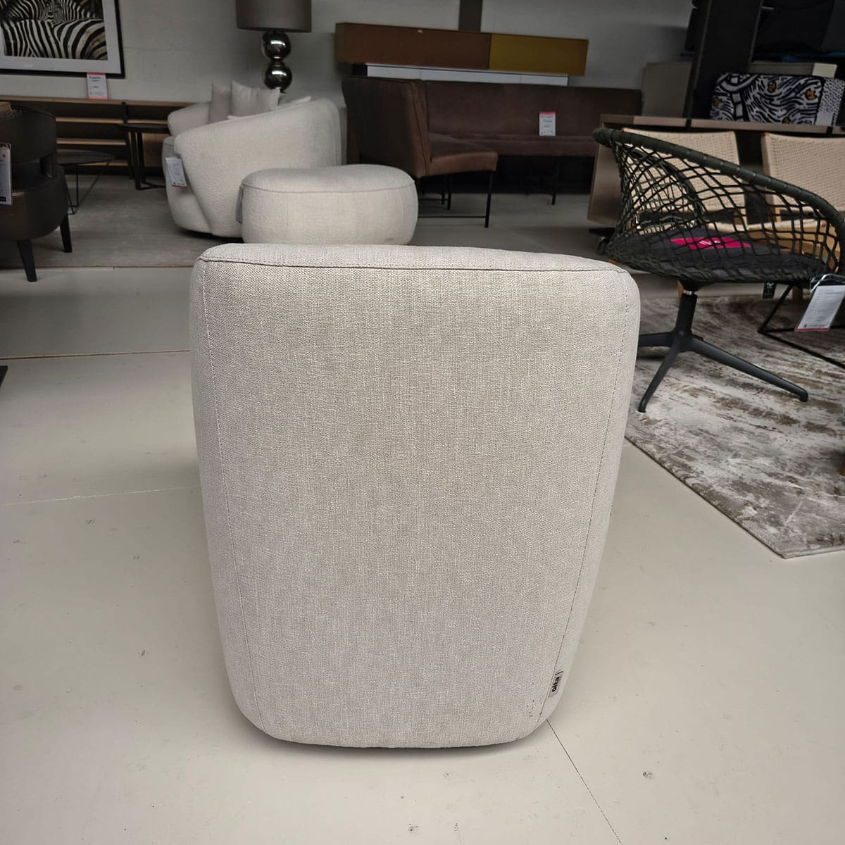 Showroommodel van een moderne fauteuil van Olta bij Houweling Interieur. Design fauteuil uitgevoerd in crème stof.
