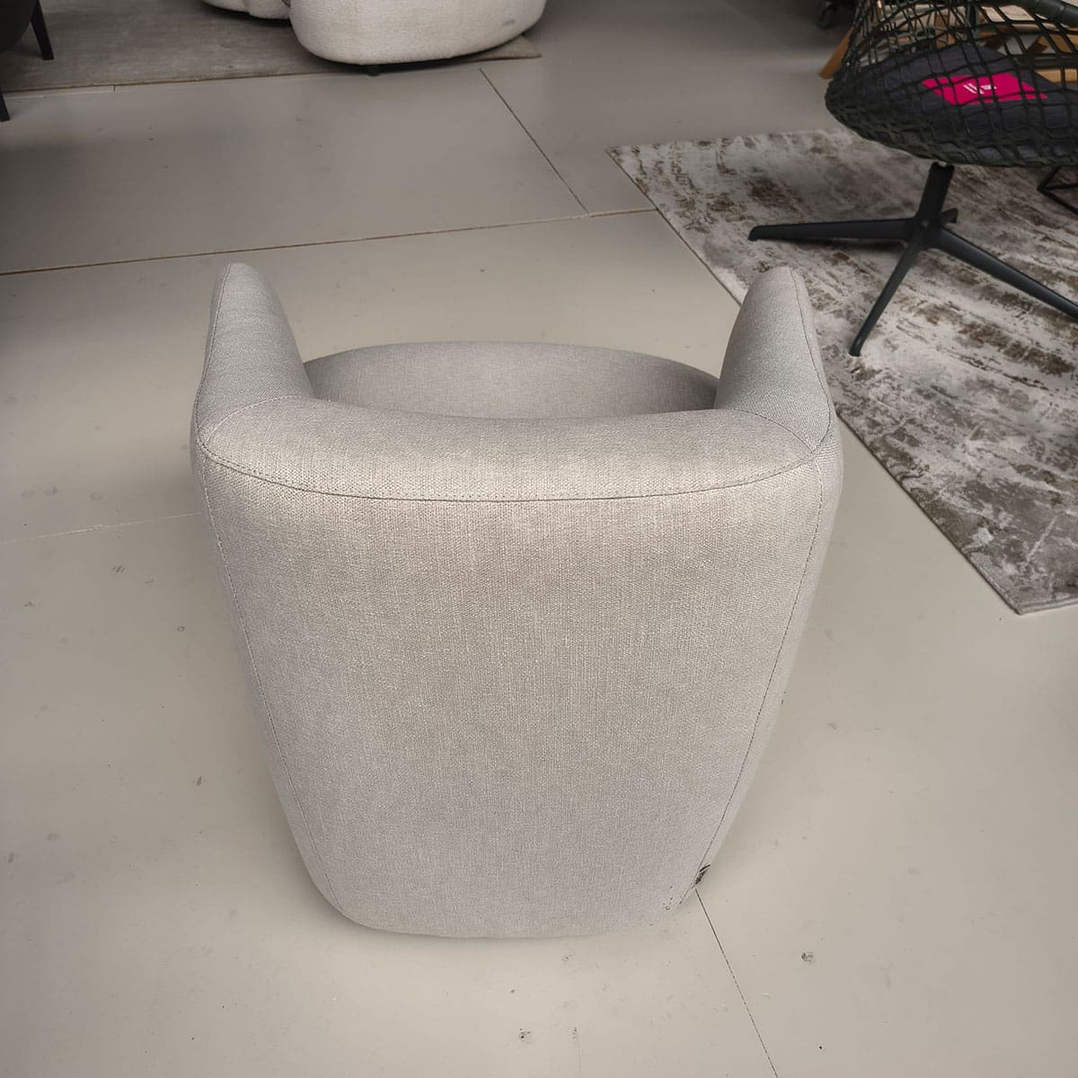 Showroommodel van een moderne fauteuil van Olta bij Houweling Interieur. Design fauteuil uitgevoerd in crème stof.
