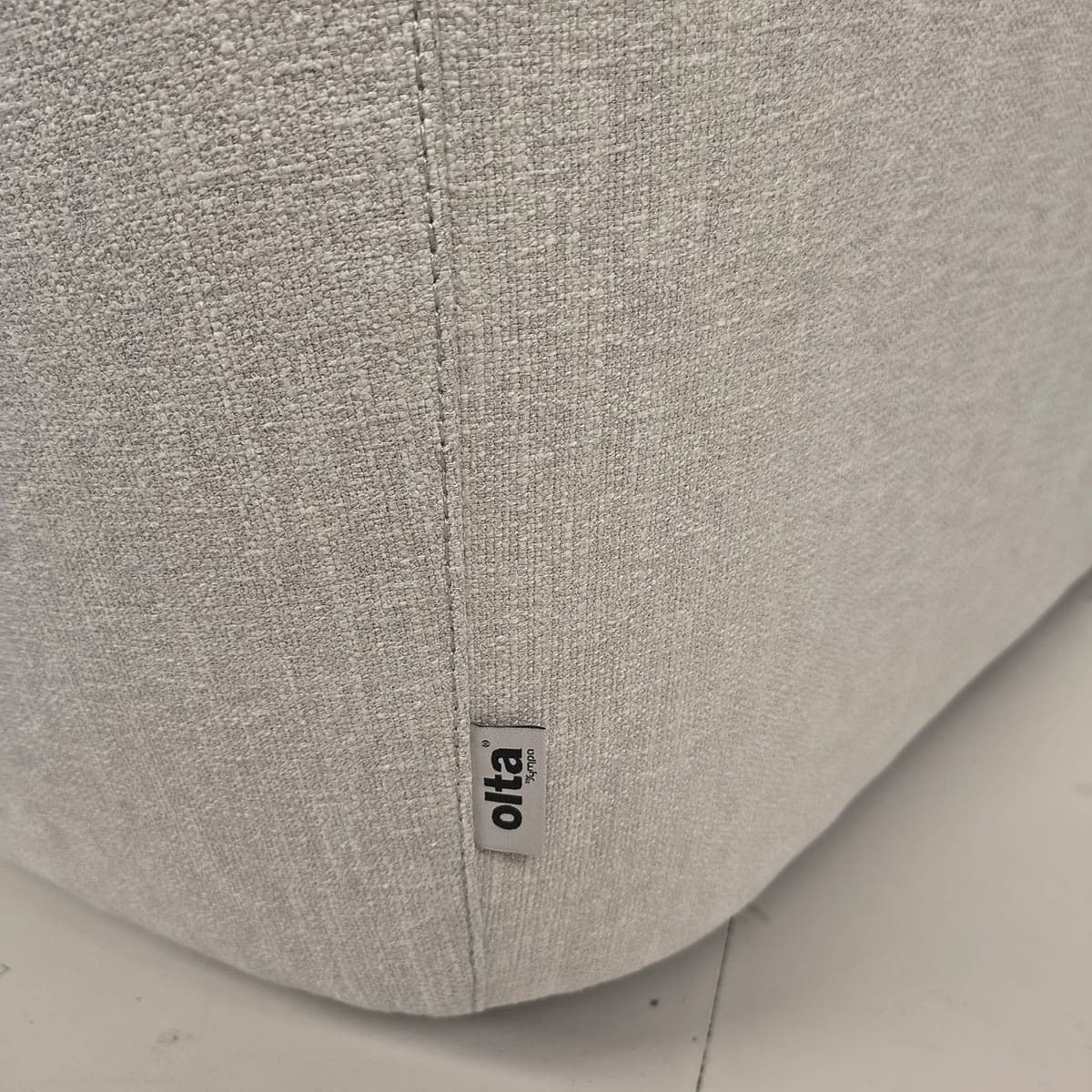Showroommodel van een moderne fauteuil van Olta bij Houweling Interieur. Design fauteuil uitgevoerd in crème stof.