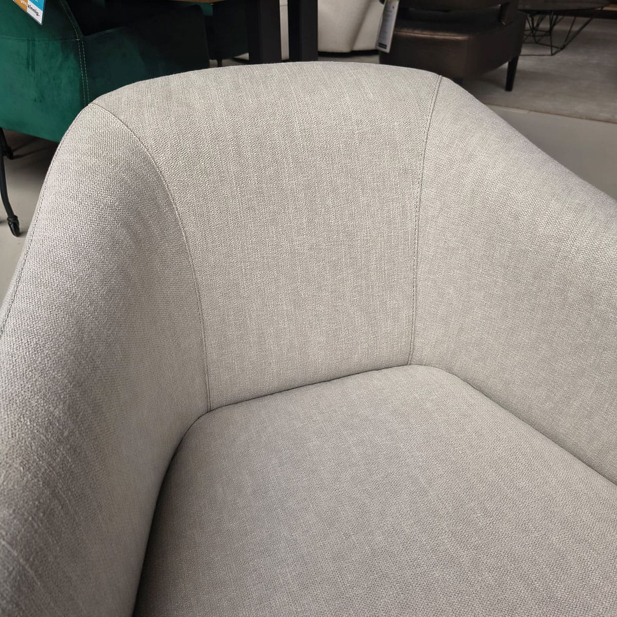 Showroommodel van een moderne fauteuil van Olta bij Houweling Interieur. Design fauteuil uitgevoerd in crème stof.