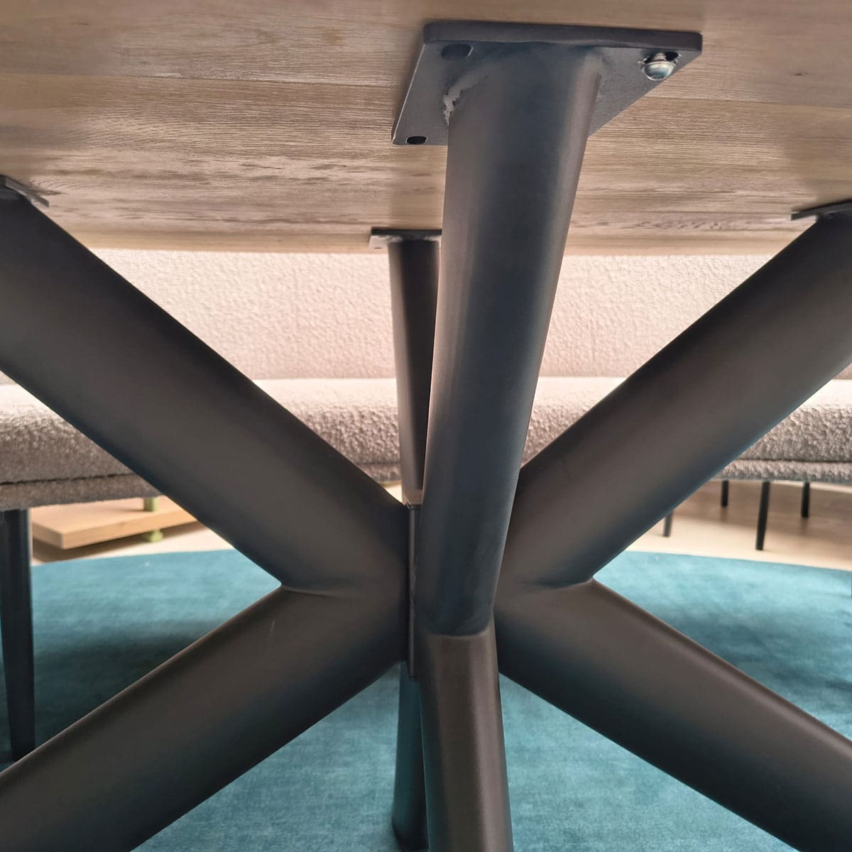 Showroommodel van een ovale eettafel bij Houweling Interieur. Houten eettafel uitgevoerd met bruinmetalen spinpoot.