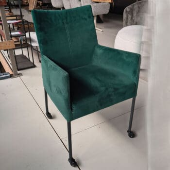 Showroommodel van groene eetkamerstoelen bij Houweling Interieur. Eetkamerstoel met wieltjes en armen.