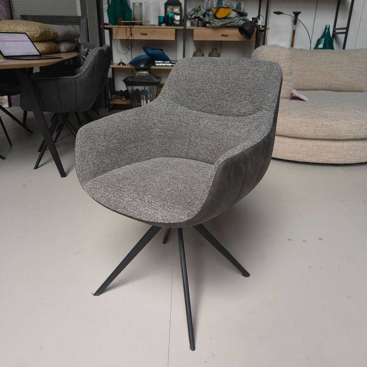 Showroommodel van luxe eetkamerstoelen bij Houweling Interieur. Moderne eetkamerstoelen uitgevoerd in grijze stof en leer.