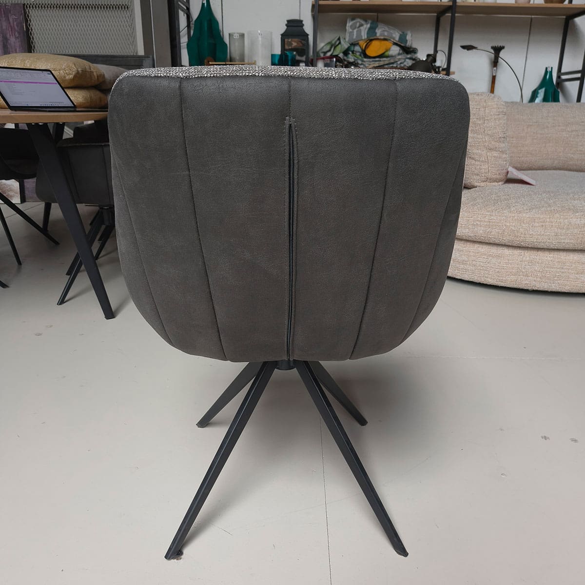 Showroommodel van luxe eetkamerstoelen bij Houweling Interieur. Moderne eetkamerstoelen uitgevoerd in grijze stof en leer.