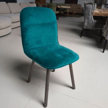 Showroommodel van design eetkamerstoel bij Houweling Interieur. Moderne eetkamerstoel uitgevoerd in turquoise stof.