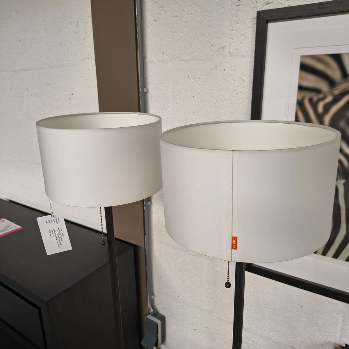 Showroommodellen van moderne vloerlampen bij Houweling Interieur. Staande lampen met witte kap.