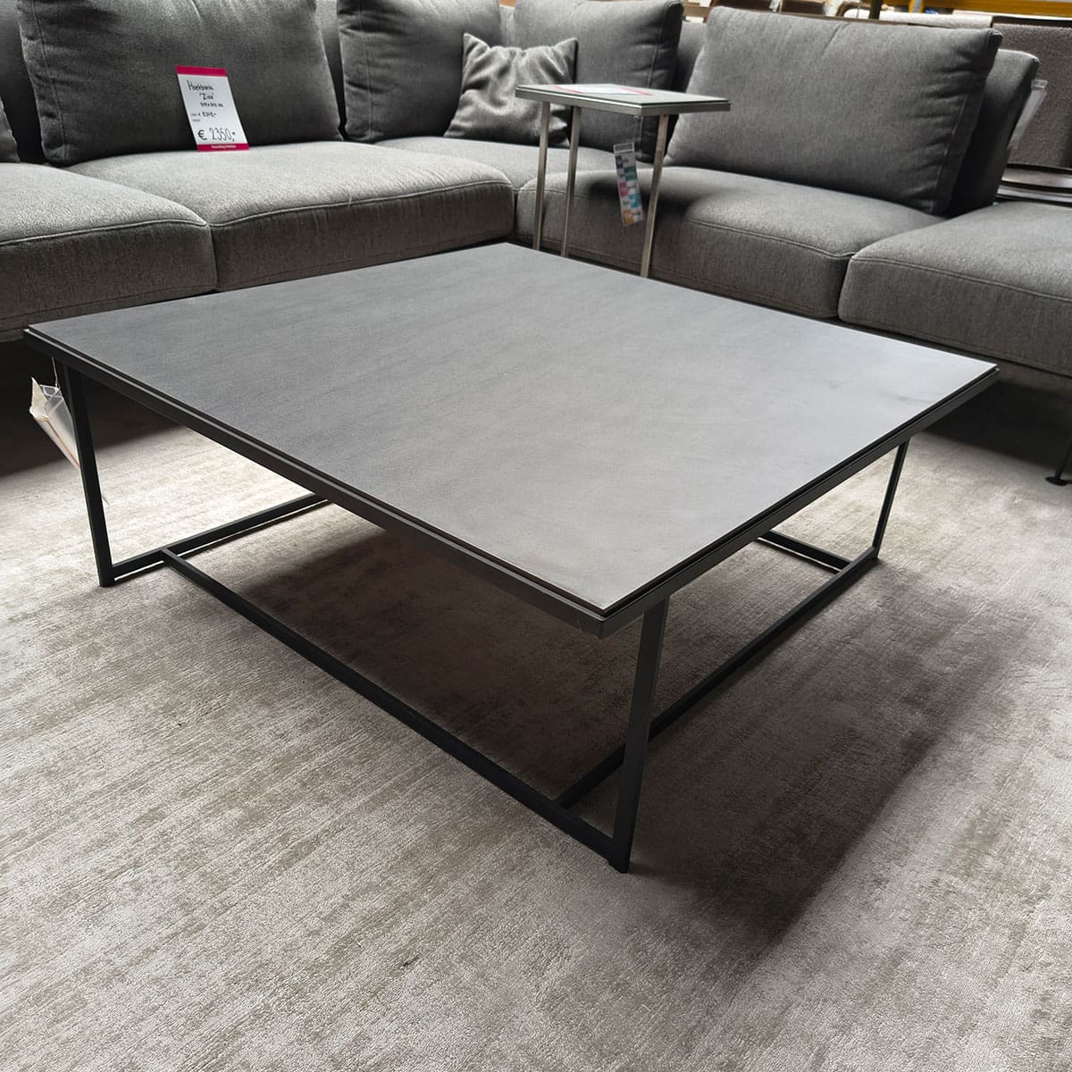 Showroommodel van design salontafel bij Houweling Interieur. Moderne salontafel met keramiek blad en zwart onderstel.