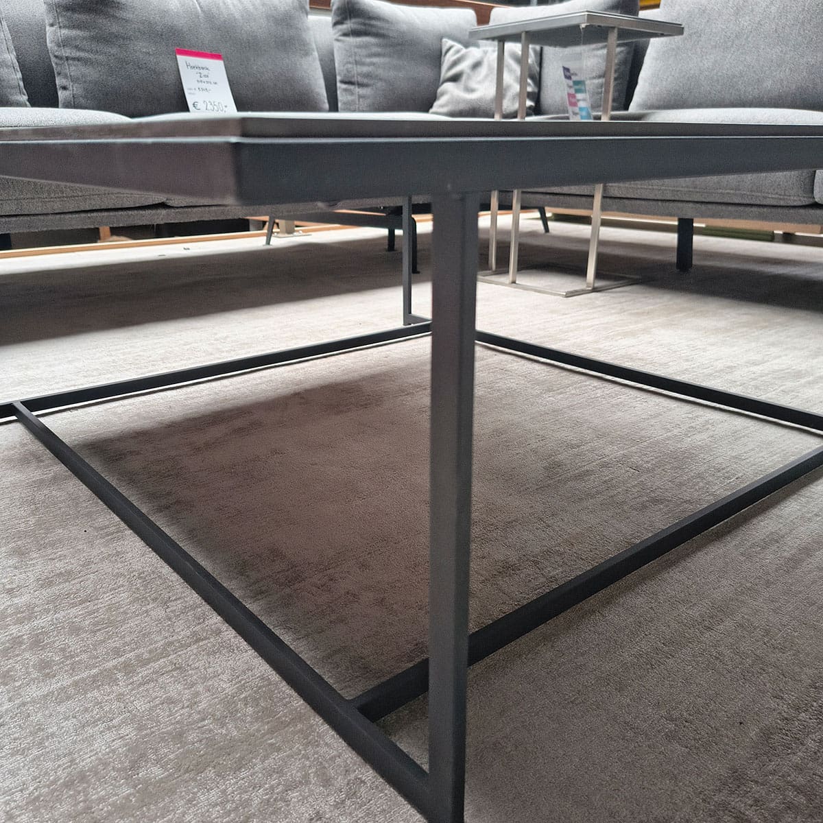Showroommodel van design salontafel bij Houweling Interieur. Moderne salontafel met keramiek blad en zwart onderstel.