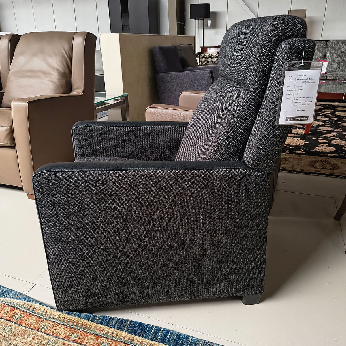 Showroommodel van relax fauteuil bij Houweling Interieur. Moderne fauteuil uitgevoerd in antraciet stof en leder.
