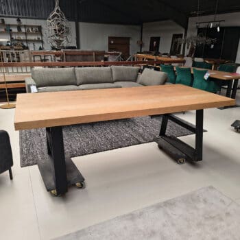 Showroommodel van industriële tafel bij Houweling Interieur. Eikenhouten tafel met zwart onderstel.