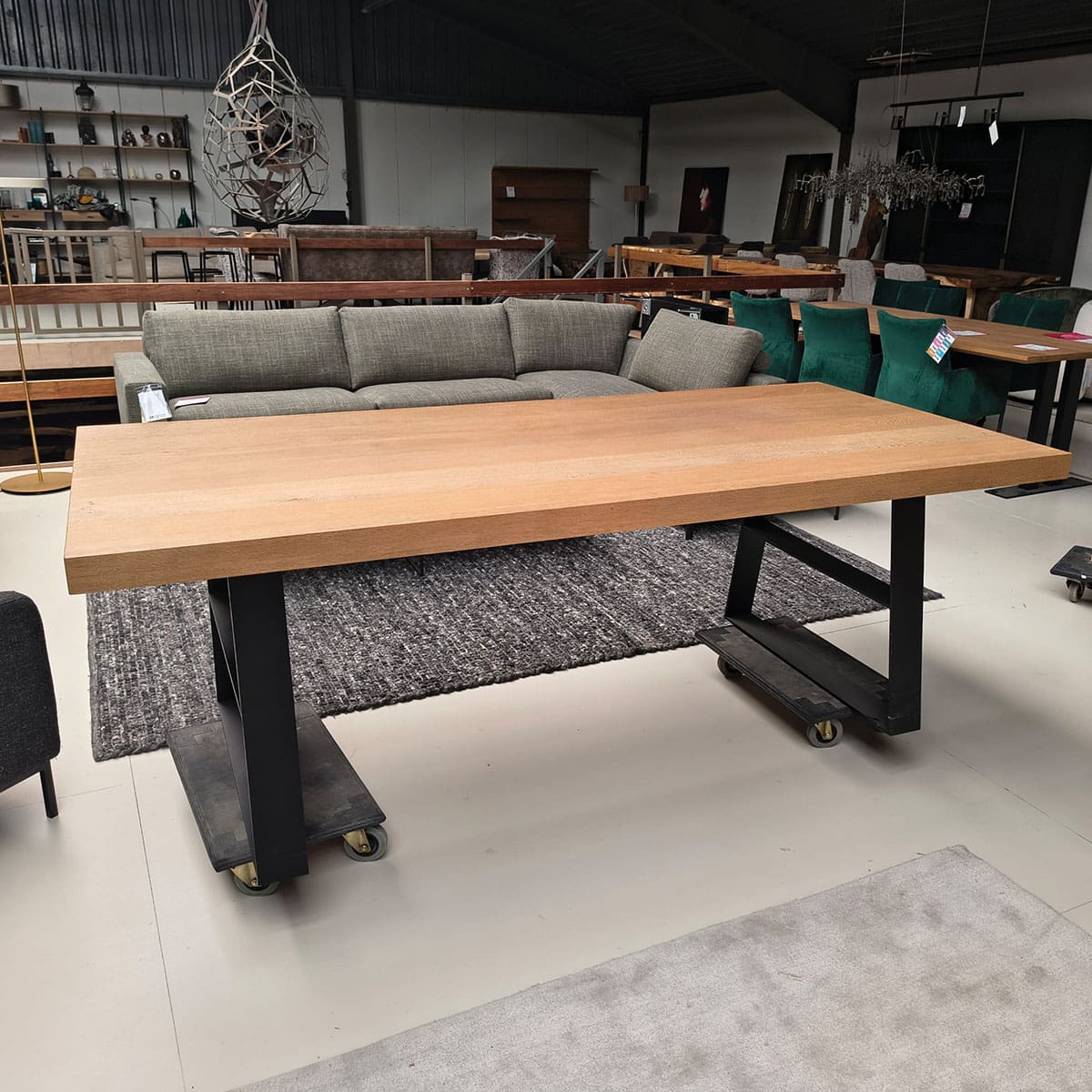 Showroommodel van industriële tafel bij Houweling Interieur. Eikenhouten tafel met zwart onderstel.