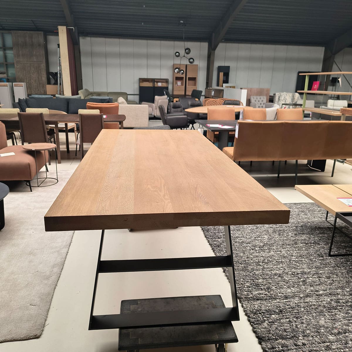 Showroommodel van industriële tafel bij Houweling Interieur. Eikenhouten tafel met zwart onderstel.