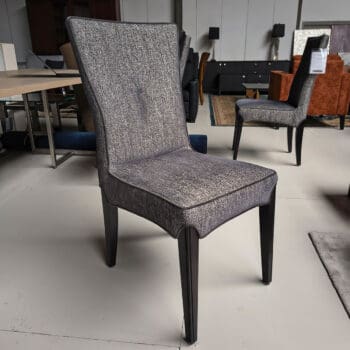 Showroommodellen van luxe eetkamerstoelen bij Houweling Interieur. Moderne eetkamerstoelen uitgevoerd in grijze stof.