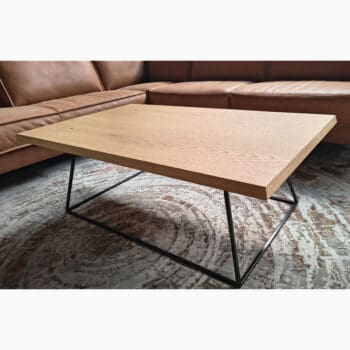 Showroommodel van houten salontafel bij Houweling Interieur. Moderne salontafel met eiken blad en zwart onderstel.