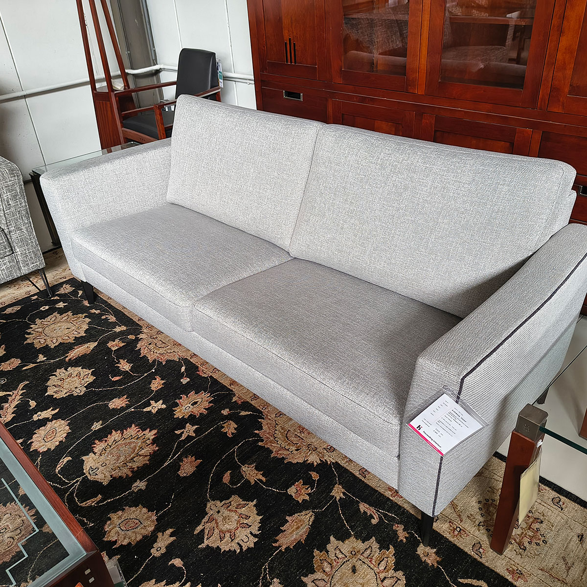 Showroommodel van design bank bij Houweling Interieur. Moderne bank uitgevoerd in lichtgrijze stof met bies.