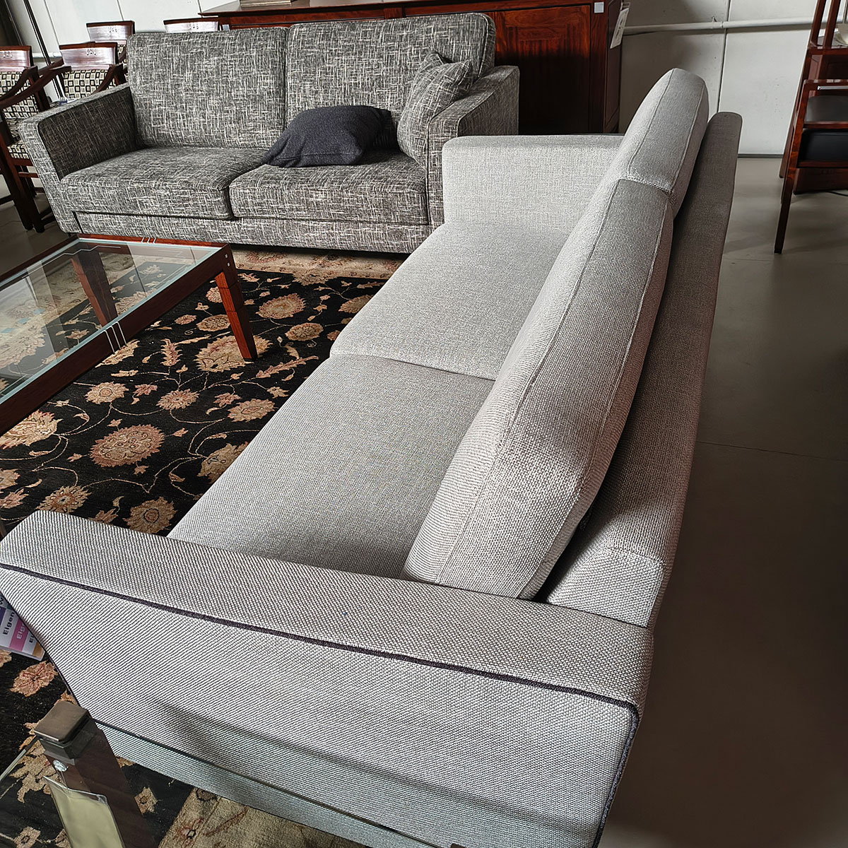 Showroommodel van design bank bij Houweling Interieur. Moderne bank uitgevoerd in lichtgrijze stof met bies.