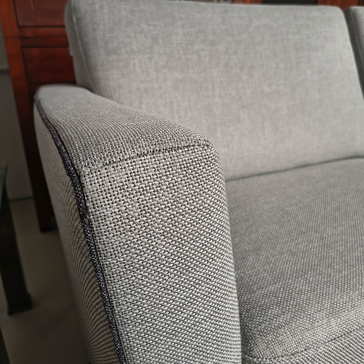 Showroommodel van design bank bij Houweling Interieur. Moderne bank uitgevoerd in lichtgrijze stof met bies.